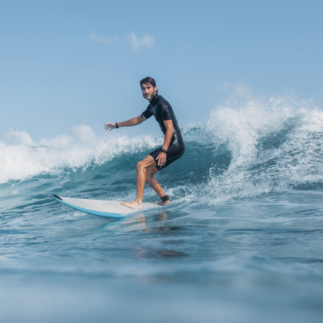 A man surfs in a springsuit, one of the best wetsuits for surfing