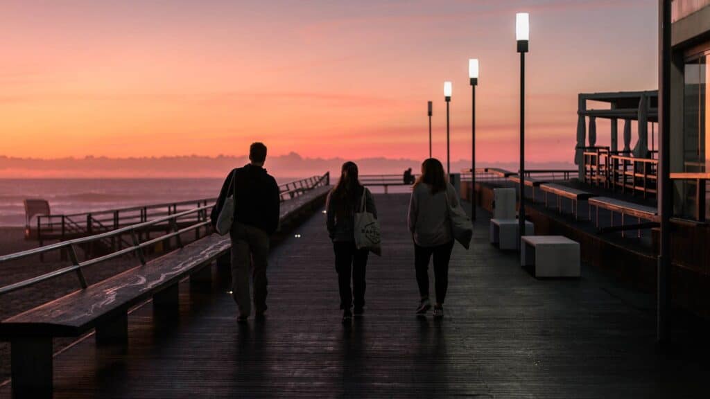 An image of a group of solo travelling rapture surfers walking near the beach at sunset