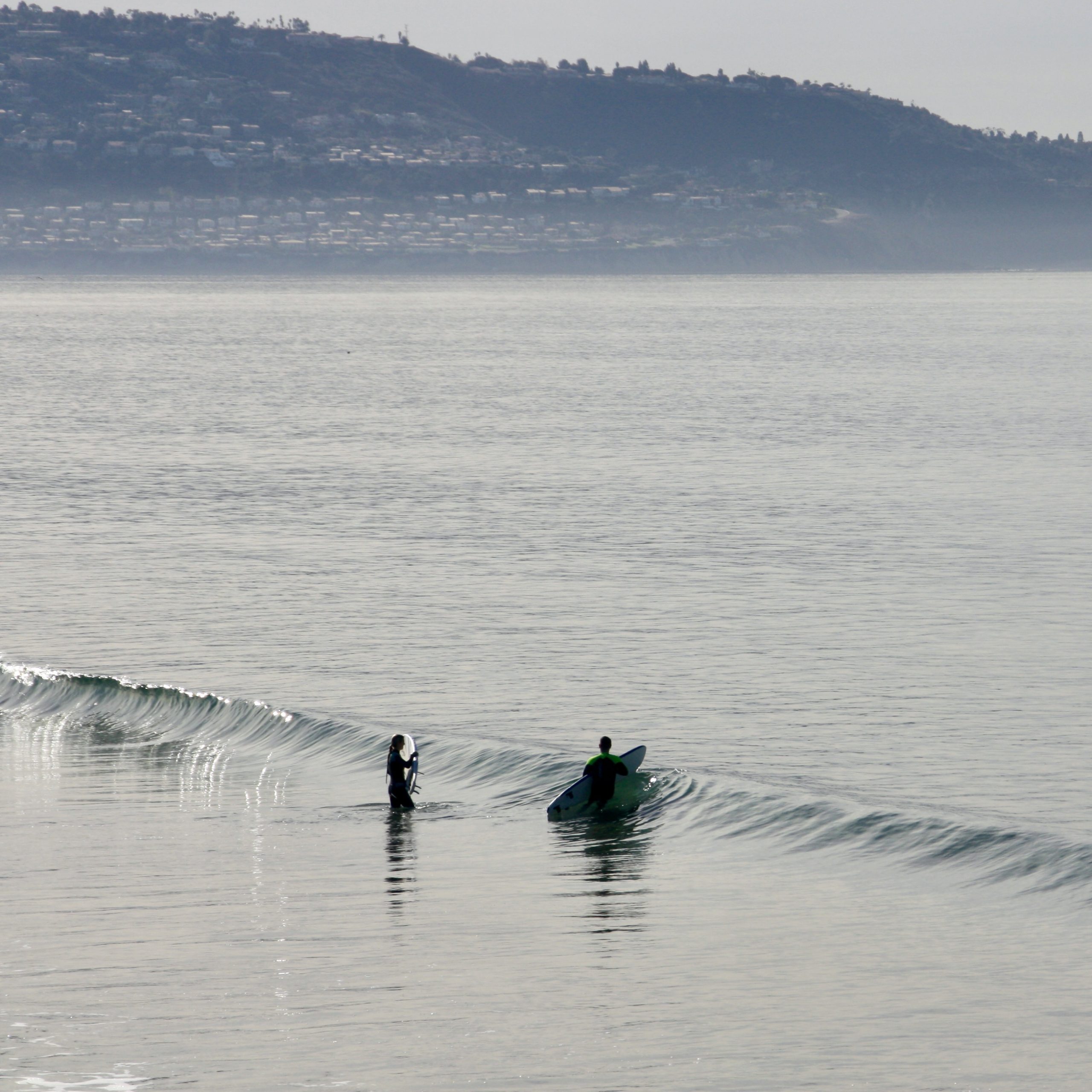 Students learn to surf at a nice, calm, flat beach. 